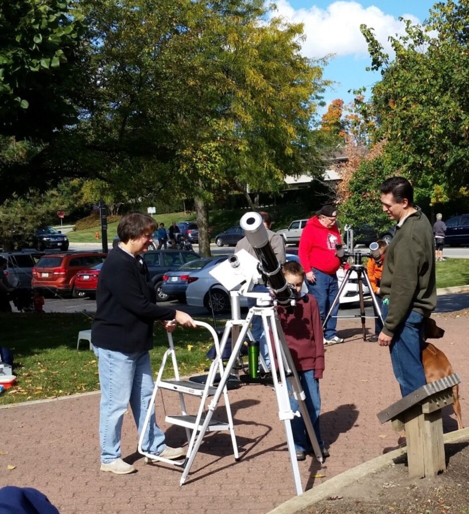 Members showing visitors the Sun through filtered telescopes on the Riverwalk